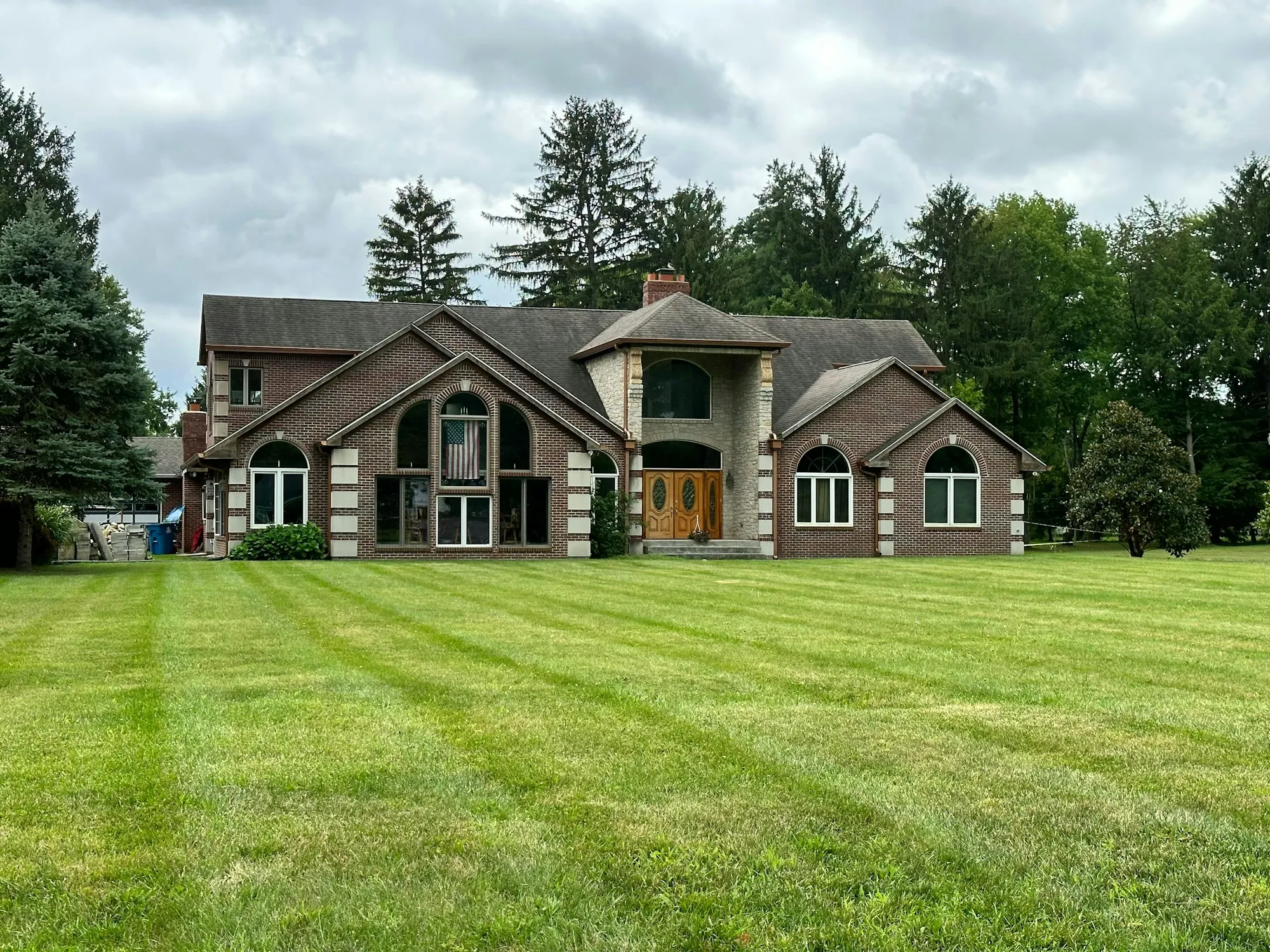 Large two-story house set back behind a wide mowed lawn